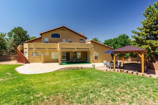 8215 Corona Ave NE, Albuquerque, NM 87122 - rear view of property featuring stucco siding, a patio, a gazebo, and a hot tub