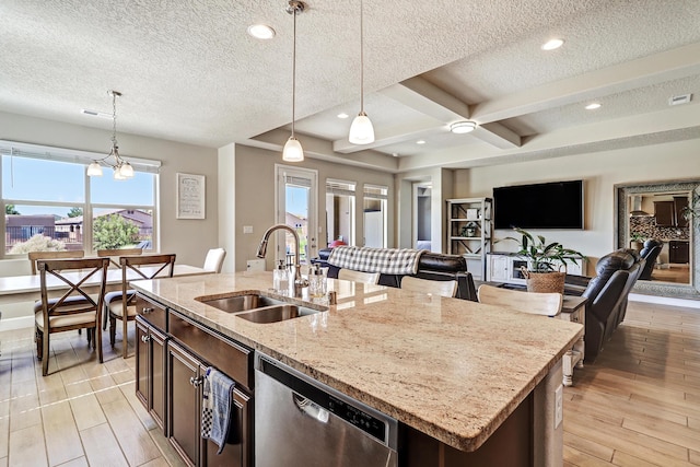 6240 Redroot St, Albuquerque, NM 87120 - kitchen with stainless steel dishwasher, a sink, open floor plan, decorative light fixtures, and a textured ceiling