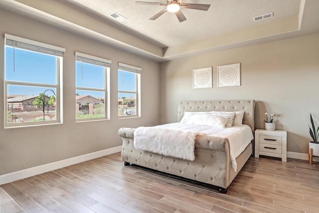6240 Redroot St, Albuquerque, NM 87120 - bedroom featuring a textured ceiling, baseboards, light wood-type flooring, a ceiling fan, and a tray ceiling