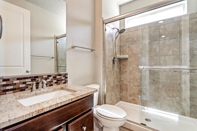 6240 Redroot St, Albuquerque, NM 87120 - full bathroom with toilet, decorative backsplash, a tile shower, and vanity