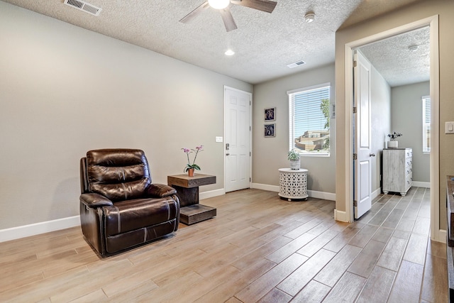 6240 Redroot St, Albuquerque, NM 87120 - sitting room with light wood-type flooring, a ceiling fan, baseboards, and a textured ceiling