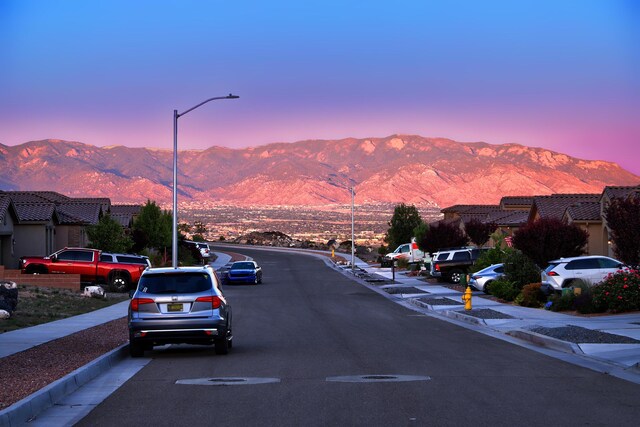 6240 Redroot St, Albuquerque, NM 87120 - view of asphalt road with a mountain view, sidewalks, and street lighting