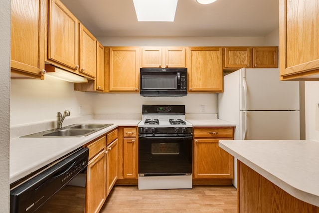 600 Aztec Rd NW, Albuquerque, NM 87107 - kitchen with black appliances, light wood finished floors, light countertops, and a sink