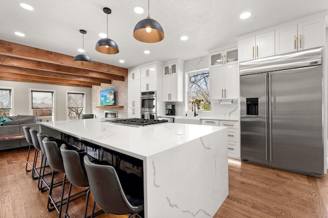 6401 Meadow Hills St NE, Albuquerque, NM 87111 - kitchen featuring appliances with stainless steel finishes, recessed lighting, wood finished floors, a center island, and white cabinetry