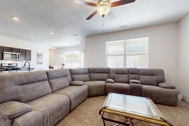 2317 Solara Loop NE, Rio Rancho, NM 87144 - living room with light carpet, a textured ceiling, and ceiling fan