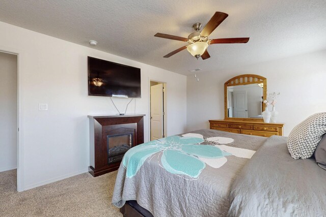 2317 Solara Loop NE, Rio Rancho, NM 87144 - carpeted bedroom with a fireplace, a ceiling fan, and a textured ceiling