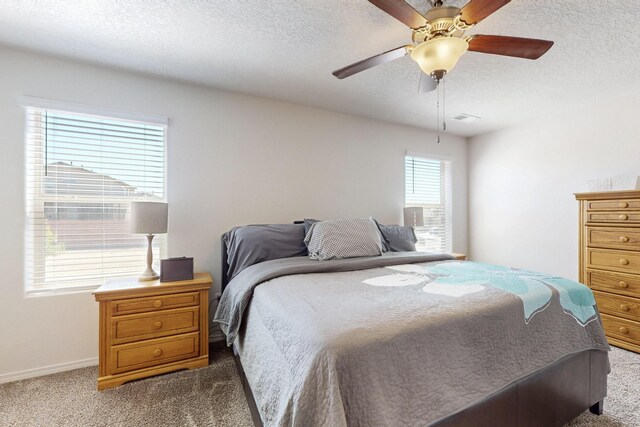 2317 Solara Loop NE, Rio Rancho, NM 87144 - bedroom featuring dark carpet, a textured ceiling, and a ceiling fan