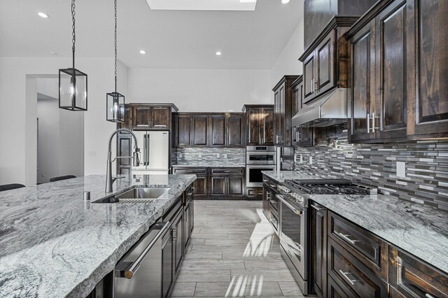 11 Del Cerro Ct, Los Lunas, NM 87031 - kitchen with appliances with stainless steel finishes, a sink, light stone counters, decorative backsplash, and dark brown cabinets
