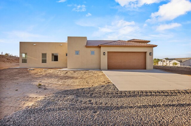 11 Del Cerro Ct, Los Lunas, NM 87031 - southwest-style home with concrete driveway, an attached garage, stucco siding, and metal roof