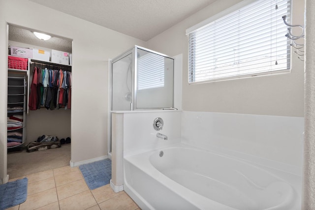 8331 Wild Dunes Ave NW, Albuquerque, NM 87120 - bathroom with a stall shower, a garden tub, a walk in closet, a textured ceiling, and tile patterned flooring