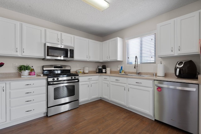 8331 Wild Dunes Ave NW, Albuquerque, NM 87120 - kitchen featuring appliances with stainless steel finishes, a sink, white cabinetry, light countertops, and a textured ceiling