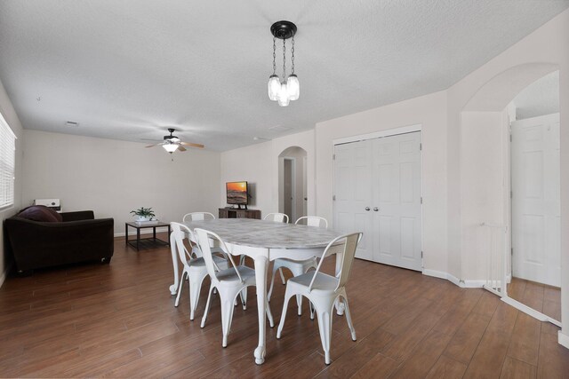 8331 Wild Dunes Ave NW, Albuquerque, NM 87120 - dining space with arched walkways, a ceiling fan, dark wood finished floors, a textured ceiling, and baseboards