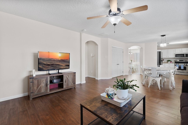 8331 Wild Dunes Ave NW, Albuquerque, NM 87120 - living area featuring arched walkways, wood finished floors, a textured ceiling, ceiling fan, and baseboards