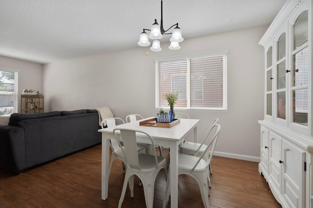 8331 Wild Dunes Ave NW, Albuquerque, NM 87120 - dining space featuring a chandelier, dark wood-type flooring, a textured ceiling, and baseboards