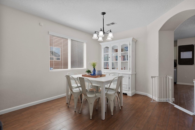 8331 Wild Dunes Ave NW, Albuquerque, NM 87120 - dining room featuring arched walkways, dark wood-style flooring, baseboards, a textured ceiling, and a chandelier