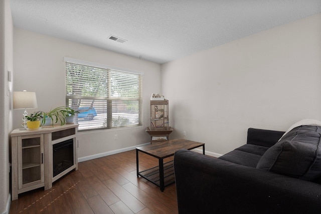 8331 Wild Dunes Ave NW, Albuquerque, NM 87120 - living area featuring dark wood finished floors, baseboards, and a textured ceiling