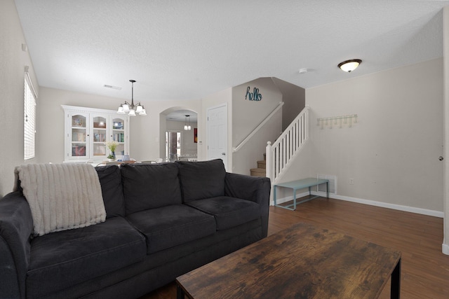8331 Wild Dunes Ave NW, Albuquerque, NM 87120 - living room featuring arched walkways, wood finished floors, stairs, baseboards, and a chandelier