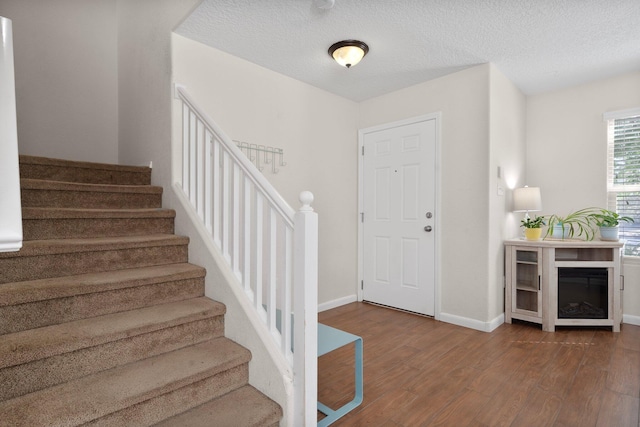 8331 Wild Dunes Ave NW, Albuquerque, NM 87120 - entryway with dark wood-type flooring, stairway, baseboards, and a textured ceiling
