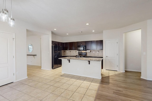 9624 Basalt Peak Dr NW, Albuquerque, NM 87114 - kitchen featuring black appliances, a sink, a kitchen breakfast bar, light stone countertops, and tasteful backsplash
