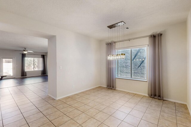 9624 Basalt Peak Dr NW, Albuquerque, NM 87114 - unfurnished room featuring a chandelier, light tile patterned floors, a textured ceiling, a ceiling fan, and baseboards