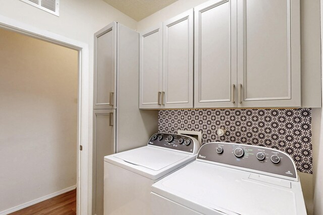 9624 Basalt Peak Dr NW, Albuquerque, NM 87114 - washroom with washing machine and dryer, cabinet space, wood finished floors, and baseboards