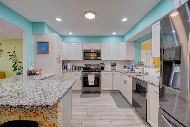 10008 Propps St NE, Albuquerque, NM 87112 - kitchen featuring appliances with stainless steel finishes, decorative backsplash, white cabinets, and recessed lighting