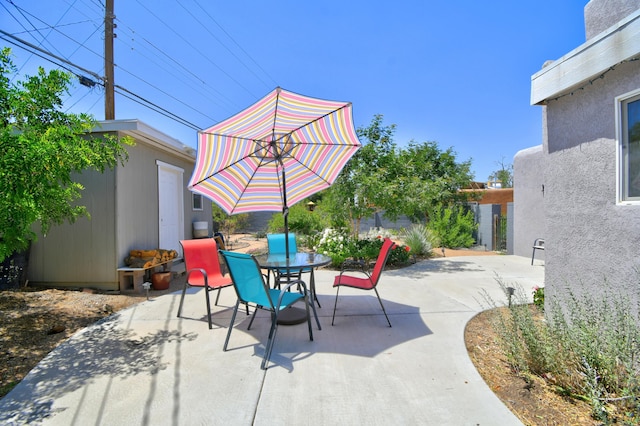 10008 Propps St NE, Albuquerque, NM 87112 - view of patio featuring outdoor dining space and an outbuilding
