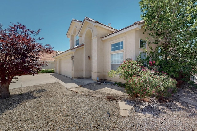 9401 Cactus Trail Rd NW, Albuquerque, NM 87114 - view of side of home with stucco siding, an attached garage, a tiled roof, and concrete driveway