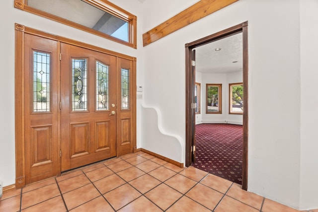 6116 Agate Ave NW, Albuquerque, NM 87120 - entryway featuring baseboards, light tile patterned flooring, light carpet, and beam ceiling