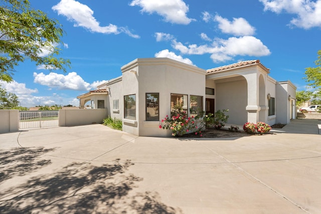 6116 Agate Ave NW, Albuquerque, NM 87120 - rear view of house with a tiled roof, stucco siding, and a patio area
