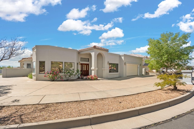 6116 Agate Ave NW, Albuquerque, NM 87120 - mediterranean / spanish-style home with a garage, concrete driveway, stucco siding, and a tiled roof