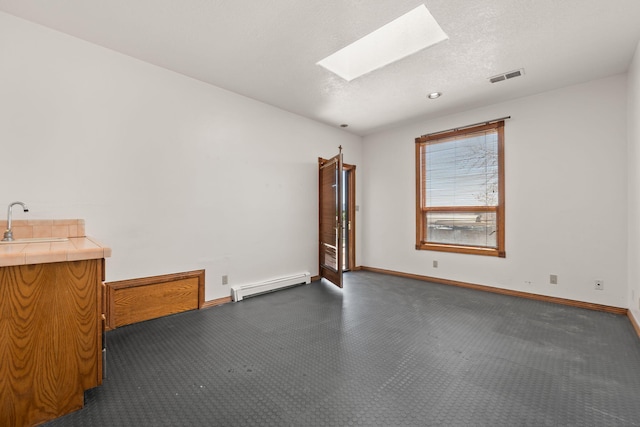 6116 Agate Ave NW, Albuquerque, NM 87120 - unfurnished room with a baseboard heating unit, a skylight, a sink, and baseboards