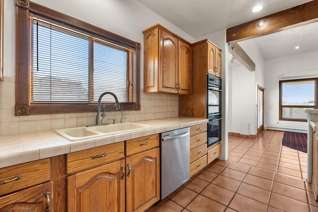 6116 Agate Ave NW, Albuquerque, NM 87120 - kitchen featuring stainless steel dishwasher, a sink, backsplash, light tile patterned flooring, and tile counters