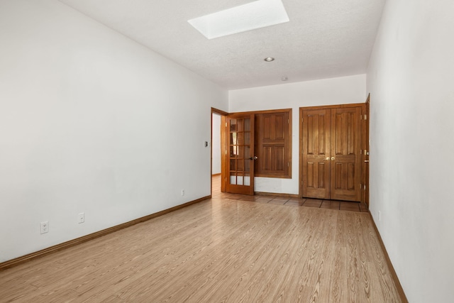 6116 Agate Ave NW, Albuquerque, NM 87120 - empty room featuring a skylight, wood finished floors, and baseboards