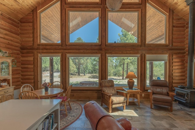 31 Smokey Bear Rd, Ramah, NM 87321 - living area with a wood stove, high vaulted ceiling, stone tile floors, plenty of natural light, and rustic walls