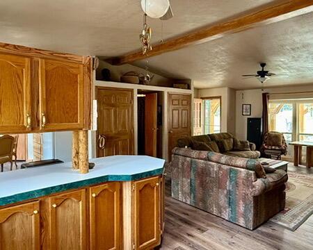 34 Halcon Rd, Ramah, NM 87321 - kitchen with open floor plan, brown cabinets, light wood-style floors, and a ceiling fan