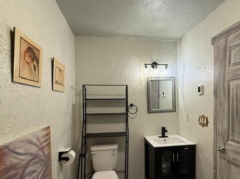 34 Halcon Rd, Ramah, NM 87321 - half bathroom with toilet, vanity, and a textured wall