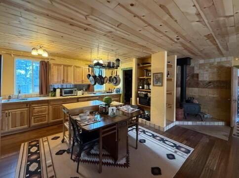 34 Halcon Rd, Ramah, NM 87321 - dining area with a chandelier, a wood stove, and light wood finished floors