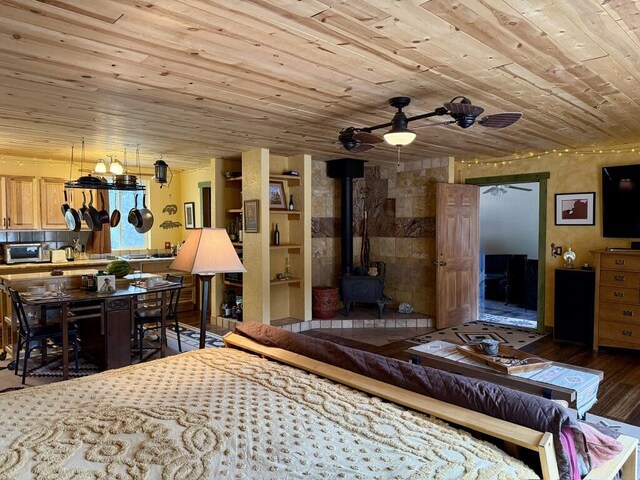 34 Halcon Rd, Ramah, NM 87321 - bedroom with wooden ceiling, a wood stove, and wood finished floors