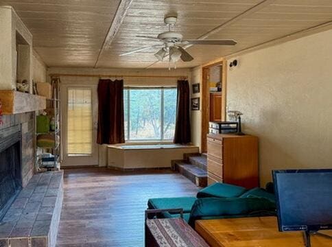 34 Halcon Rd, Ramah, NM 87321 - living room with wooden ceiling, ceiling fan, a fireplace with raised hearth, and wood finished floors