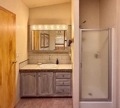 34 Halcon Rd, Ramah, NM 87321 - full bathroom with vanity, a stall shower, tile patterned floors, and backsplash