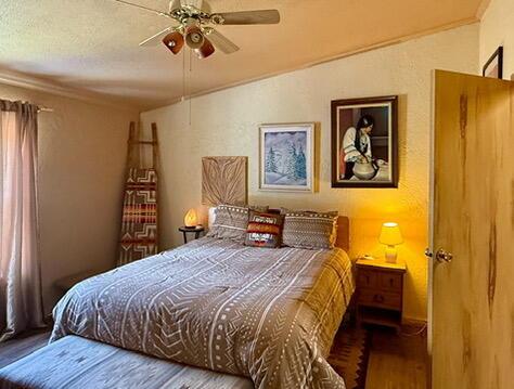 34 Halcon Rd, Ramah, NM 87321 - bedroom featuring wood finished floors, vaulted ceiling, a ceiling fan, and ornamental molding