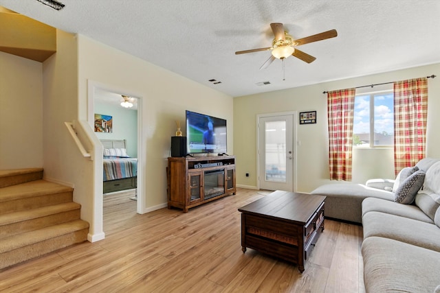 2115 Cortina Loop SE, Rio Rancho, NM 87124 - living area with ceiling fan, light wood-type flooring, stairway, baseboards, and a textured ceiling