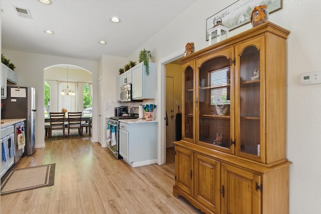 2115 Cortina Loop SE, Rio Rancho, NM 87124 - kitchen featuring stainless steel appliances, arched walkways, light countertops, light wood-style floors, and recessed lighting