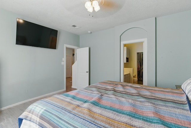 2115 Cortina Loop SE, Rio Rancho, NM 87124 - bedroom featuring connected bathroom, baseboards, ceiling fan, and wood finished floors
