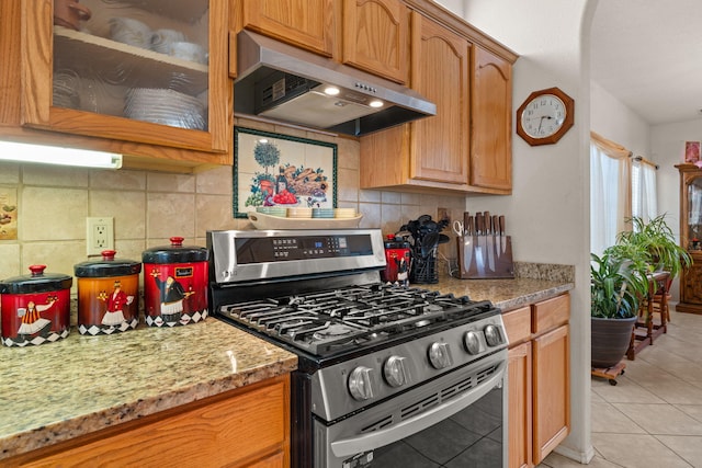 1908 Selway Pl NW, Albuquerque, NM 87120 - kitchen featuring stainless steel gas range oven, range hood, light tile patterned floors, tasteful backsplash, and glass insert cabinets