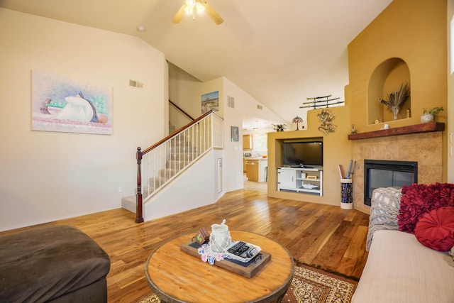 6105 Loro Ave NW, Albuquerque, NM 87114 - living room with vaulted ceiling, wood finished floors, stairs, a tiled fireplace, and ceiling fan