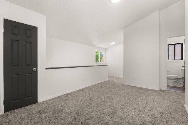 1616 Vail Pl SE, Albuquerque, NM 87106 - empty room with carpet floors, lofted ceiling, and baseboards