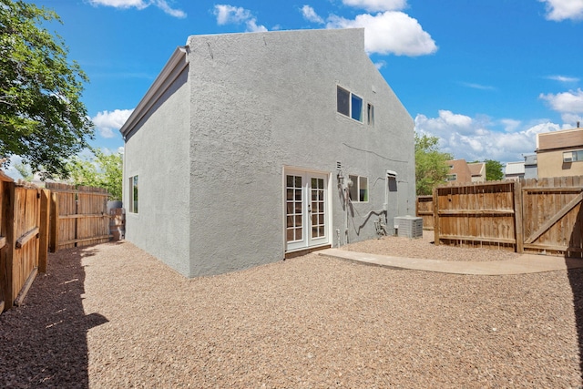 1616 Vail Pl SE, Albuquerque, NM 87106 - back of house with stucco siding, french doors, a fenced backyard, central air condition unit, and a gate