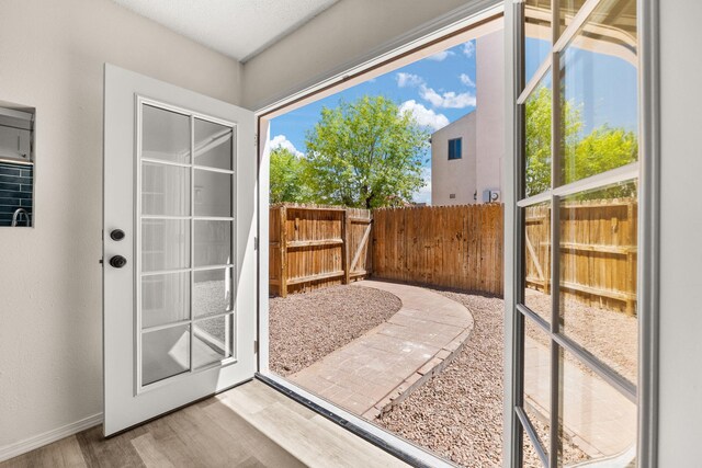 1616 Vail Pl SE, Albuquerque, NM 87106 - doorway to outside featuring wood finished floors and baseboards